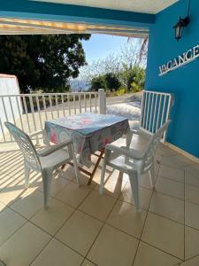 un patio con mesa y 2 sillas en Bas de villa Vacances Océan en Le Carbet