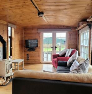 a living room with a couch and a tv at The Cabin at Forestview Farm in Greenisland