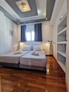 a bedroom with a large bed with blue curtains at A&D Central Apartment in Volos