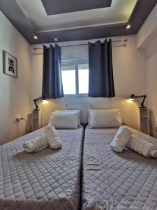 uma grande cama branca num quarto com cortinas azuis em A&D Central Apartment em Volos
