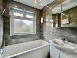 Modern 3 Bed Chigwell House (Free Parking) في تشيجويل: حمام مع حوض ومغسلة ونافذة