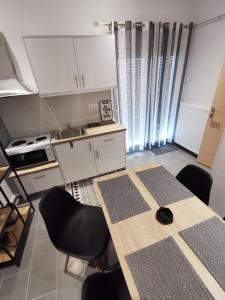 uma cozinha com mesa e cadeiras num quarto em A&D Central Apartment em Volos