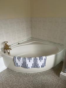 a white bath tub with a towel on it in a bathroom at Field Cottage in Whittlesey