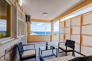 a balcony with chairs and a table with a view of the ocean at Apartmani Zalaz sunca in Blato
