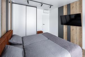 a bedroom with a bed and a flat screen tv at New designer apartments in Lviv