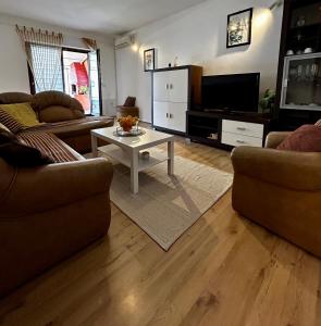 ein Wohnzimmer mit 2 Sofas und einem TV in der Unterkunft Elentoni in Fažana