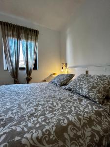 ein Schlafzimmer mit einem großen Bett und einem Fenster in der Unterkunft Elentoni in Fažana