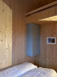 a bedroom with a bed in a wooden wall at Edvardbua in Kvalnes