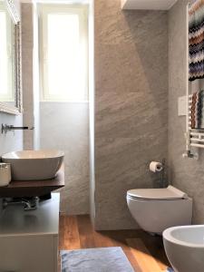 La salle de bains est pourvue de toilettes blanches et d'un lavabo. dans l'établissement Eternal City Apartment, à Rome