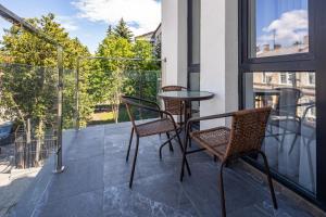 a balcony with a glass table and two chairs at New designer apartments in Lviv