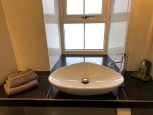 a white sink in a bathroom with a window at Townhouse in Cardigan in Cardigan