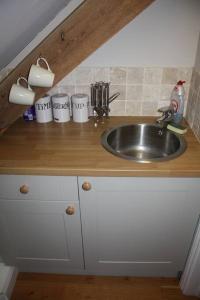 encimera de cocina con fregadero y armarios blancos en Scotland Lodge Farm, Stonehenge en Salisbury