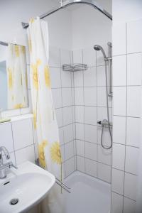 baño blanco con ducha y lavamanos en Bio-Gästehaus Rhöndistel en Poppenhausen