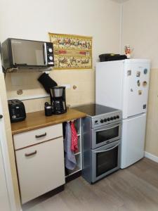 a kitchen with a stove and a refrigerator at Weather Helm, 18 Highlands Road ,Andover in Andover
