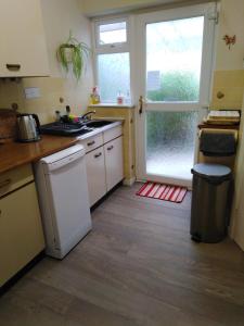 a kitchen with a sink and a refrigerator and a window at Weather Helm, 18 Highlands Road ,Andover in Andover