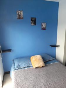 a blue bedroom with a bed with a blue wall at Apartamentos para tus vacaciones in Armenia