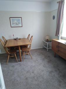 a dining room with a wooden table and chairs at Weather Helm, 18 Highlands Road ,Andover in Andover