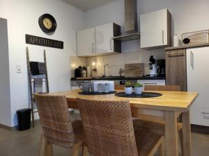 a kitchen with a wooden table and chairs at TKS-HOME Am Weiherplatz 