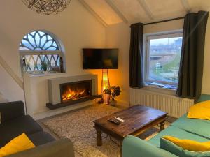 a living room with a couch and a fireplace at Riverside loft apartment in Newport