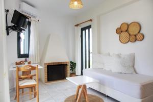 a white room with a bed and a fireplace at Koukounari Apartments in Skala