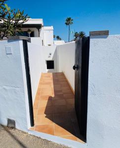 a door leading into a white wall with a pathway at Vivienda Vacacional Naia in La Asomada