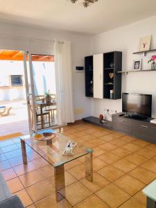 a living room with a glass table and a television at Vivienda Vacacional Naia in La Asomada