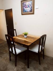 een houten tafel met twee stoelen en een plant erop bij Excelente casa para descansar in Coatzacoalcos