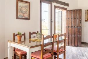 a dining room with a table and chairs and some windows at CORTIJO OHANA in Motril