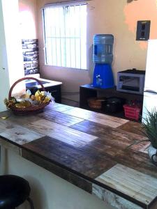 a wooden counter top with a basket of fruit on it at Casa de paso independiente para descansar por viaje in Coatzacoalcos