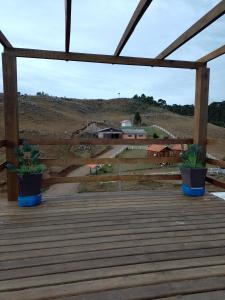 dos macetas sentadas en la parte superior de una terraza de madera en Paraíso Dos Cânions, en Bom Jardim da Serra