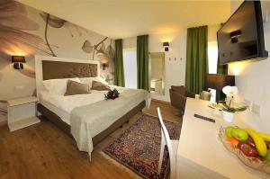 a bedroom with a bed and a living room at Hotel Florida in Levico Terme