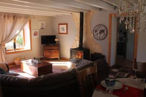 ein Wohnzimmer mit einem Sofa und einem Kamin in der Unterkunft Le Miette, family house Sleeps 6 in La Celle-sous-Gouzon