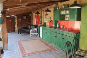 a kitchen with green cabinets and a couch in a room at Le Miette, family house Sleeps 6 in La Celle-sous-Gouzon