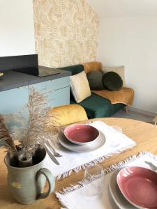 ein Wohnzimmer mit einem Tisch mit Tellern und einem Sofa in der Unterkunft Gîte Loufiosa Vannes in Vannes