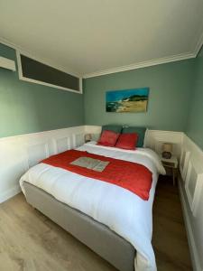 a bedroom with a large bed with red pillows at Sainte-Cécile La Cabine Chic 4 personnes in Camiers