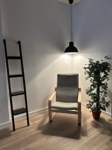 a chair and a ladder in a room with a plant at Apartamento tipo loft valencia in Paiporta