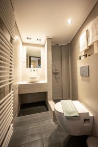 La salle de bains est pourvue de toilettes et d'un lavabo. dans l'établissement Genesis Grande Acropolis Hill Villa, à Athènes