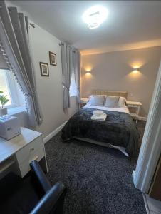 a bedroom with a bed and a desk and a chair at The Railway Crossings in Wingate
