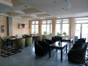 ein Restaurant mit Tischen, Stühlen und Fenstern in der Unterkunft Hotel Elegance in Belgrad