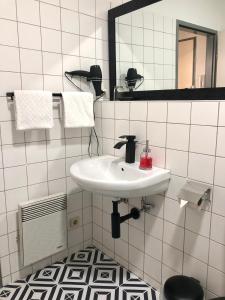 bagno bianco con lavandino e specchio di Apartman Favorita a Vienna