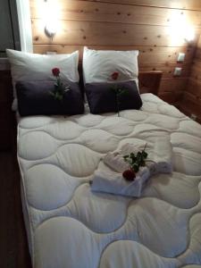 ein großes weißes Bett mit Rosen darüber in der Unterkunft La CAFRINE in Cilaos