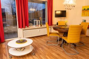 uma sala de jantar com uma mesa e cadeiras amarelas em Art City Studio Kassel 3 em Vellmar