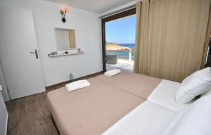 a bedroom with a large bed with a view of the ocean at Ferma Beach Villas in Ferma