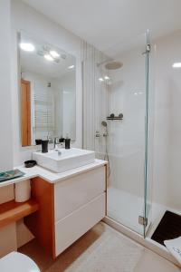 a white bathroom with a sink and a shower at Sweet living Porto in Valbom