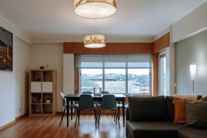 a living room with a table and chairs and a couch at Sweet living Porto in Valbom