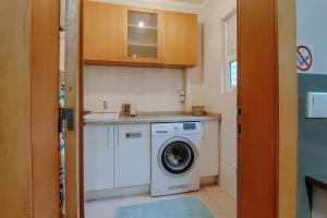 a small kitchen with a washing machine in a room at Sweet living Porto in Valbom
