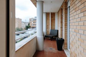a balcony with a black chair on a building at Sweet living Porto in Valbom