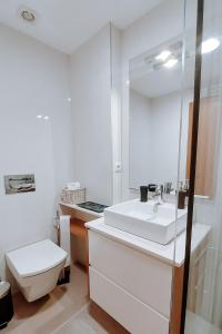 a bathroom with a white sink and a toilet at Sweet living Porto in Valbom +12 photos