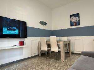 Un comedor con una mesa y un televisor en la pared. en Casa Rostri, en Lido di Ostia