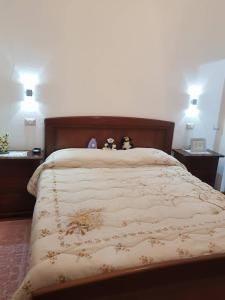 dois bichos de peluche sentados em cima de uma cama em G&E Bed & Breakfast - Austis em Austis